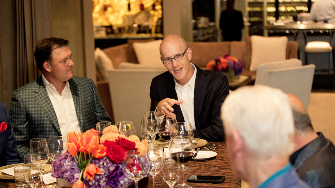 A group of individuals have a conversation over a meal