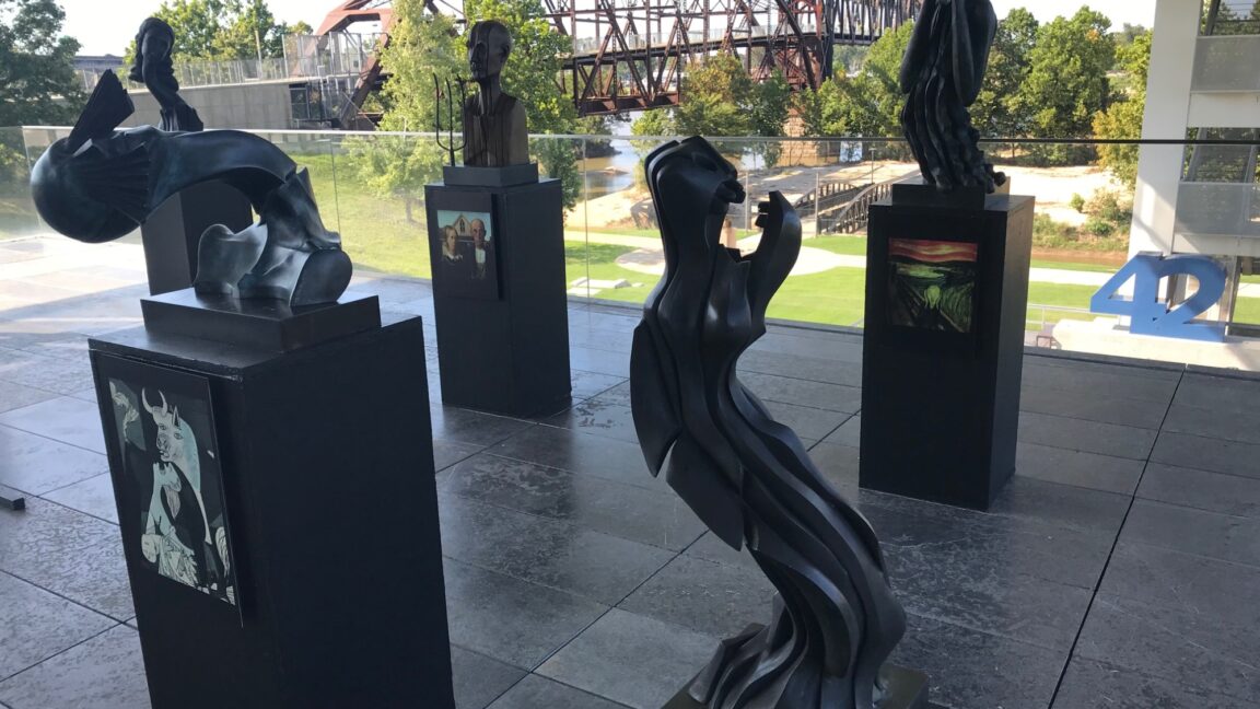 Sculptures arranged outside with Clinton Presidential Park Bridge in the background