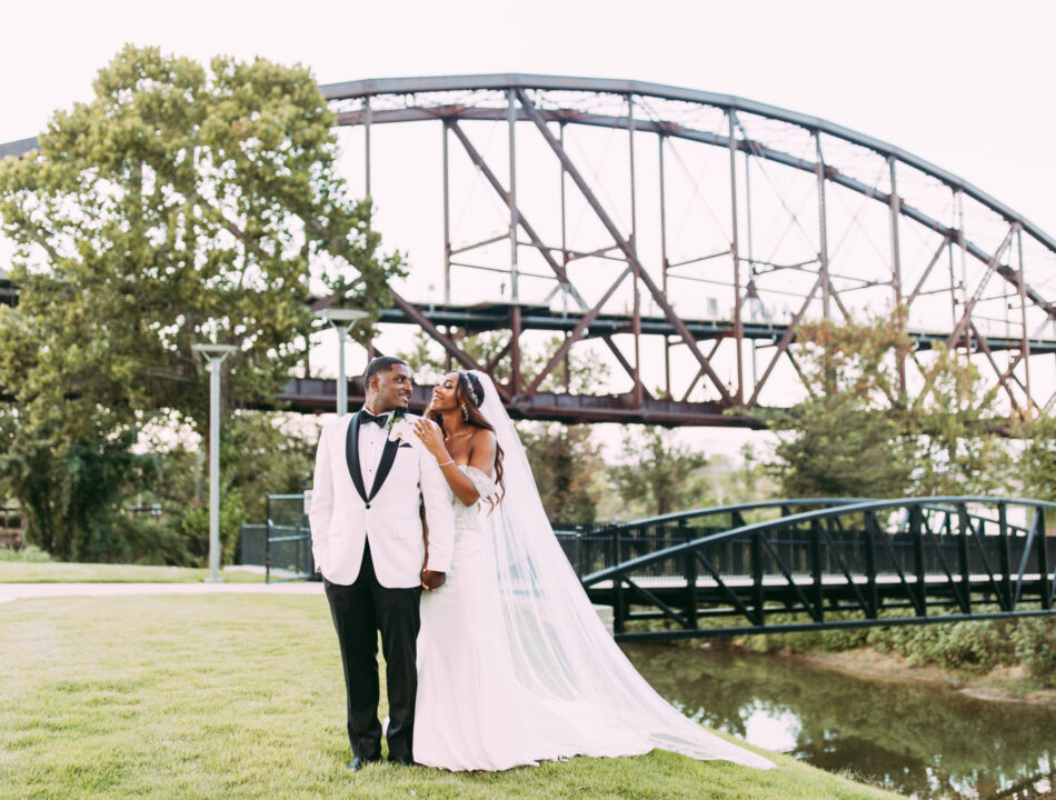 Bride and groom pose in front of Clinton Presidential Park Bridge