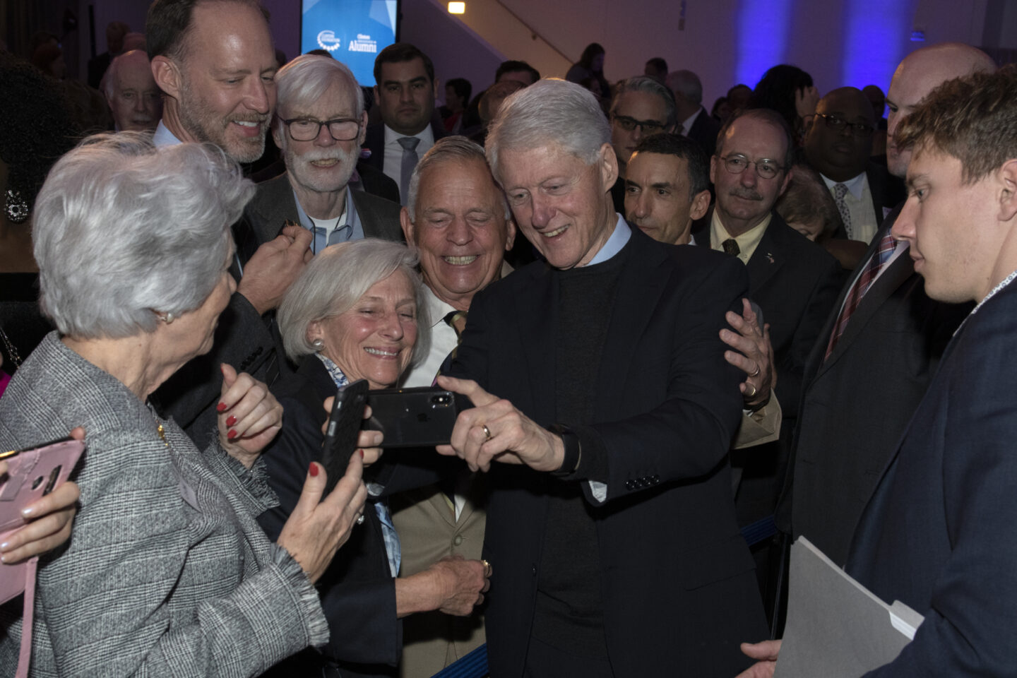 President Clinton takes a photo at an event.