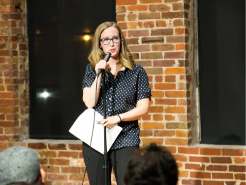 An individual holds a microphone while speaking