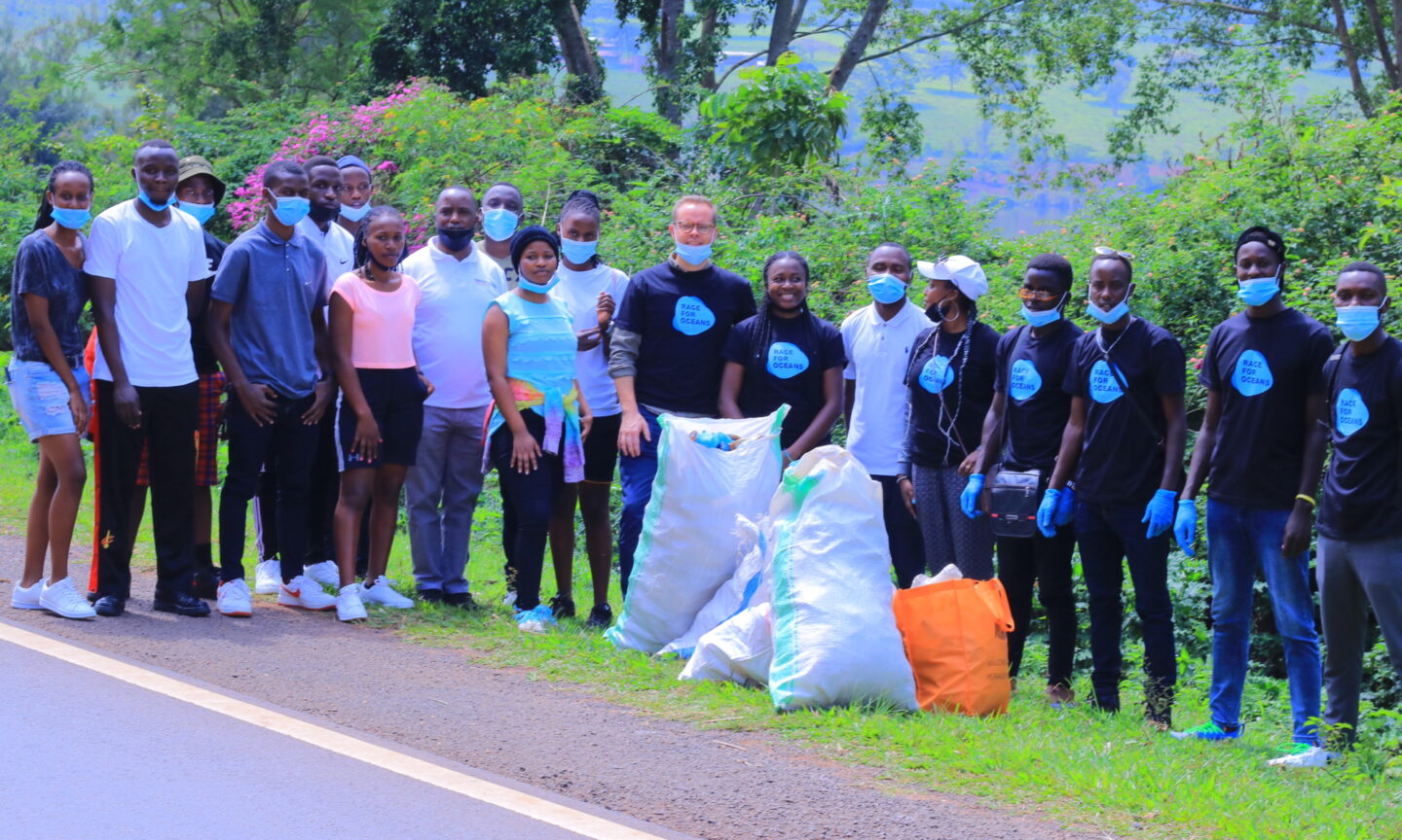 A large group of people stand behind bags for collecting recycle waste
