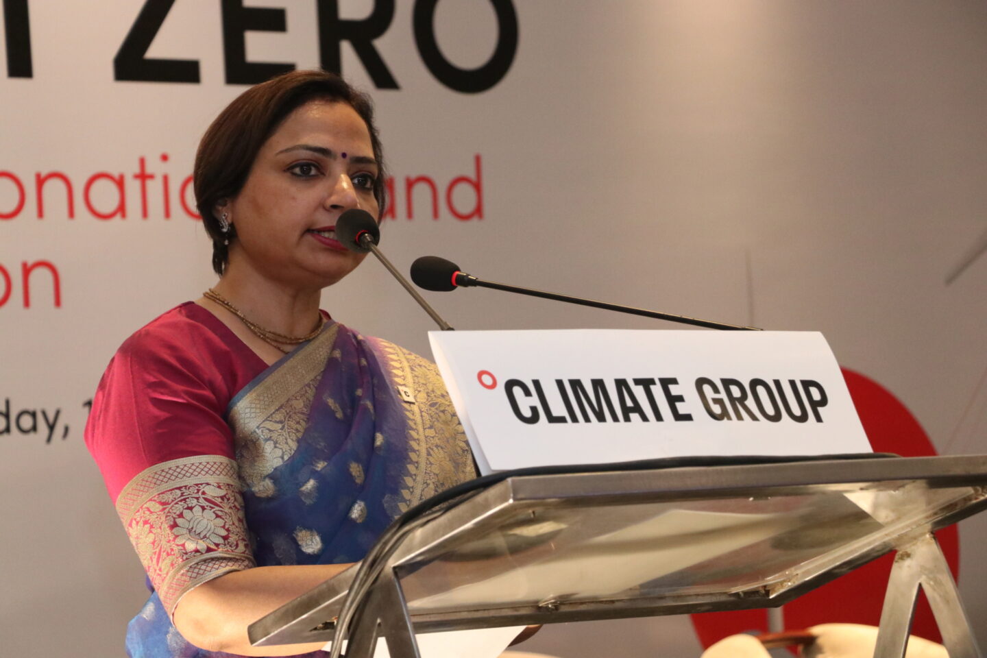 Divya Sharma speaks behind a podium that says Climate Group