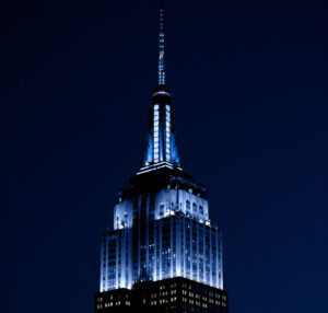 Empire State Building at night lit with blue and white lights