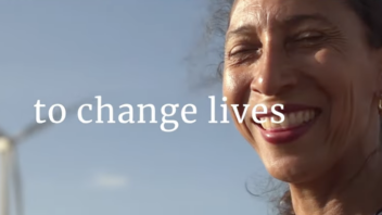 An individual smiles in front of a wind turbine. The words "to change lives" appear.