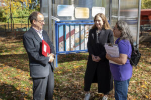 Chelsea Clinton and two individuals converse outside