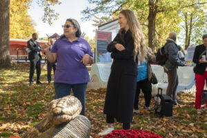 Chelsea Clinton and another individual converse outside