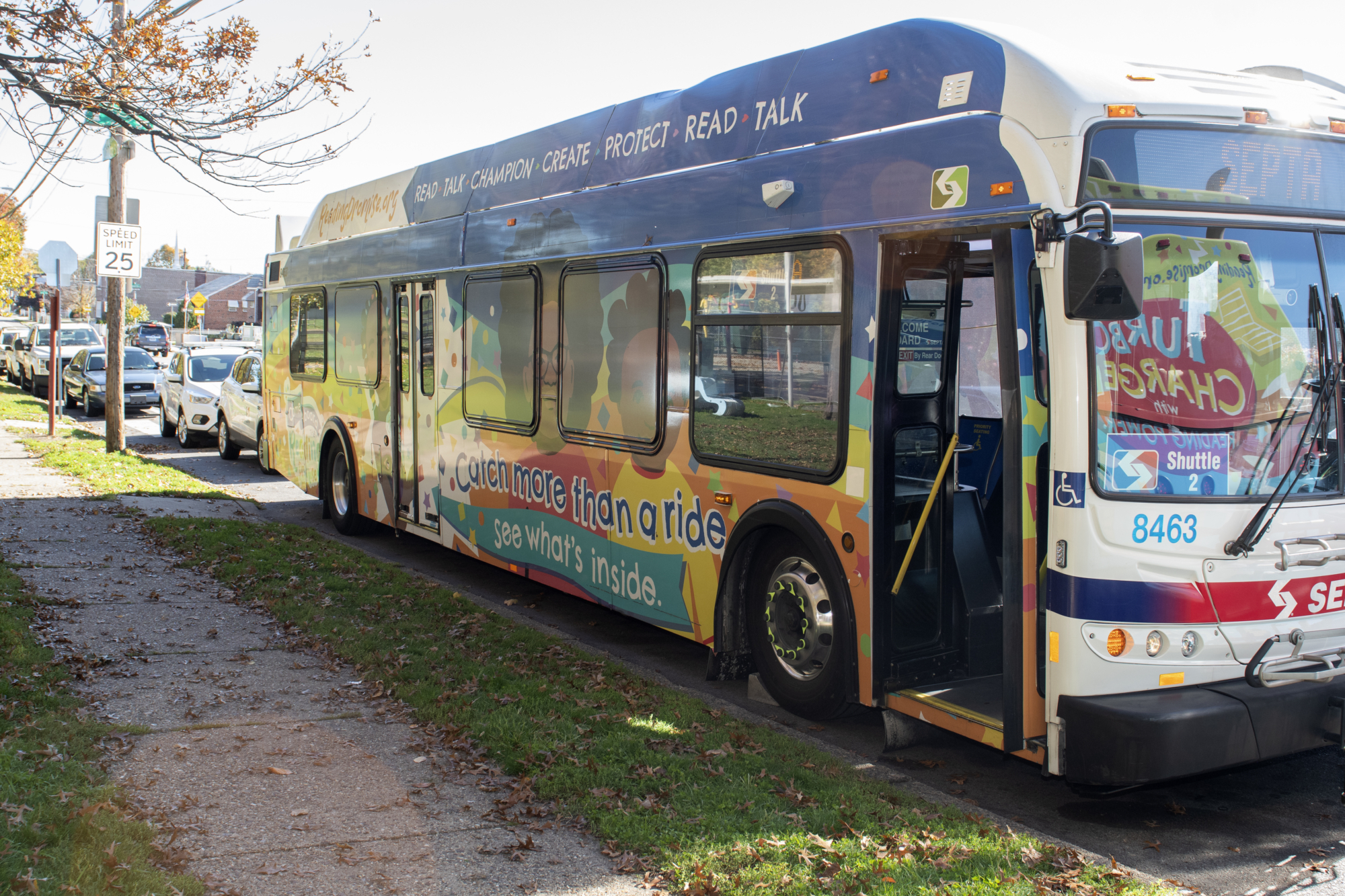 A bus is adorned with colorful illustrations and messages about early language learning