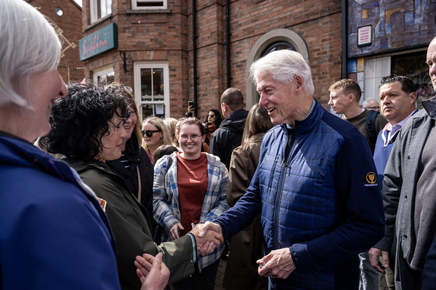 President Clinton shakes hands in a crowd outside