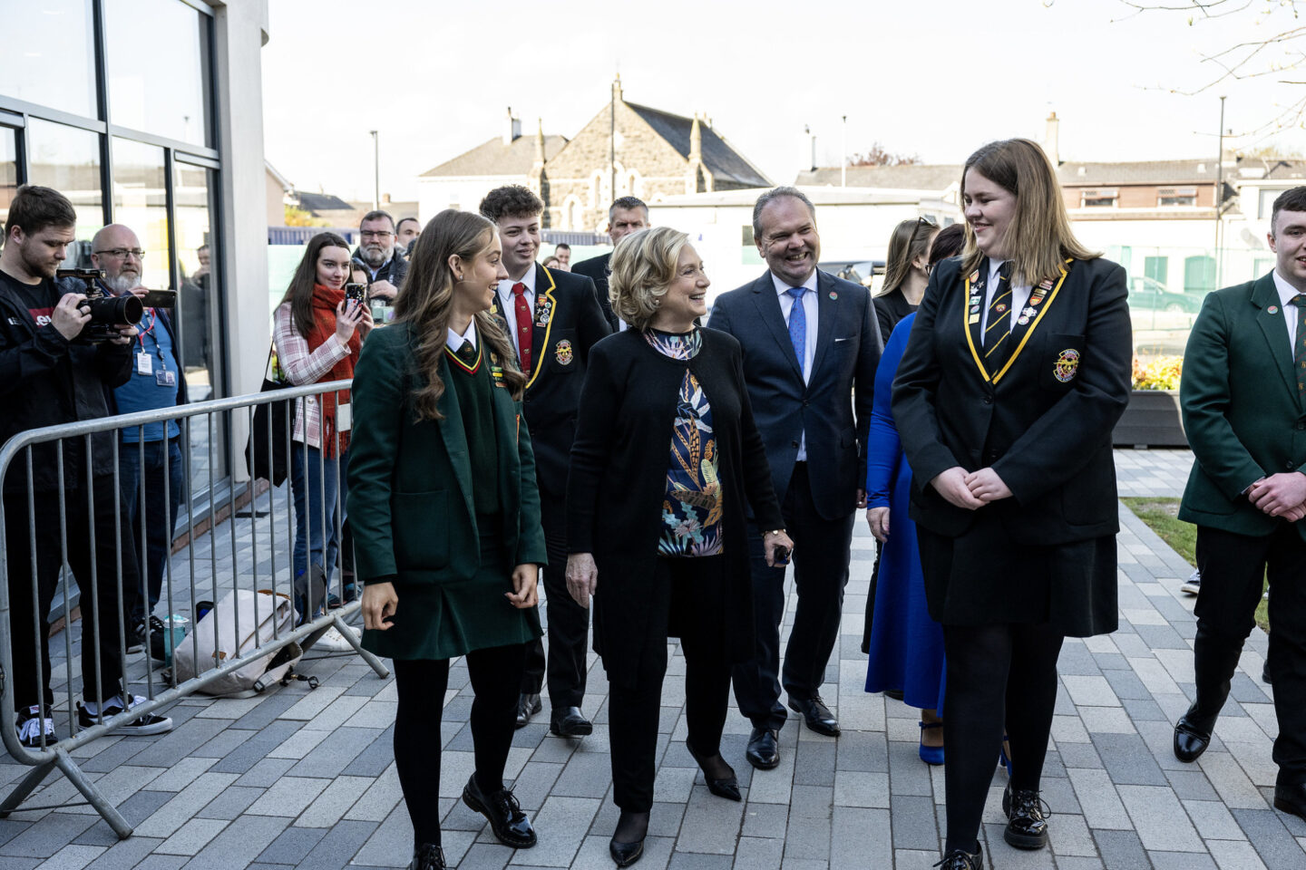 Secretary Clinton walks outside with a group of students