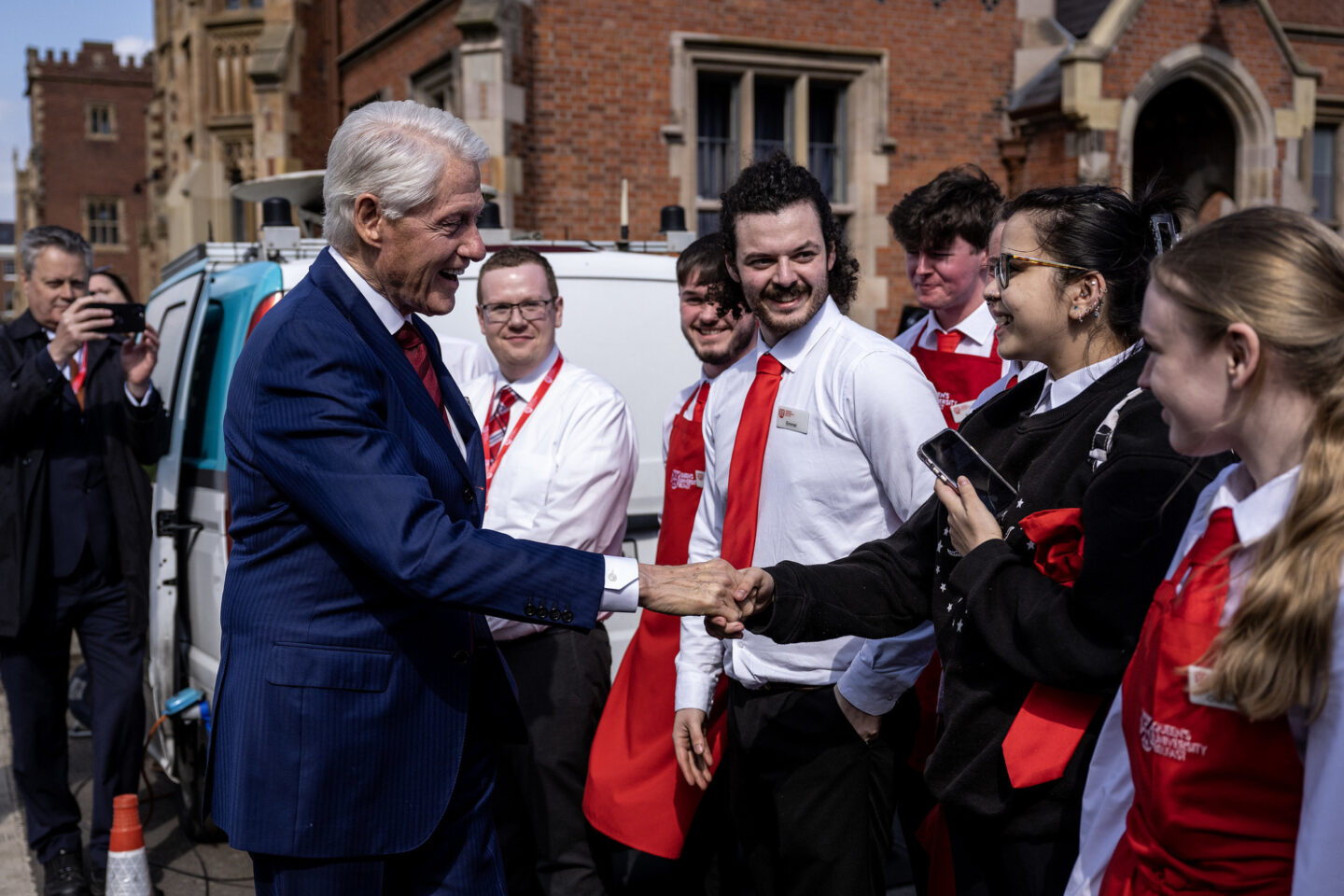 President Clinton shakes hands of students gathered outside