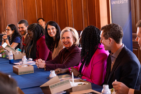 Secretary Hillary Rodham Clinton sits with students at a table at the Clinton Global Initiative University 2023 Meeting.