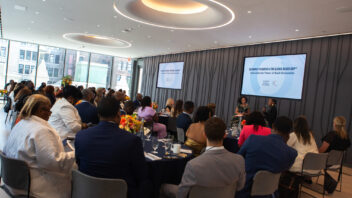 A group gathers in the audience at tables while listening to a series of conversations about Black wealth, economic prosperity, and more.